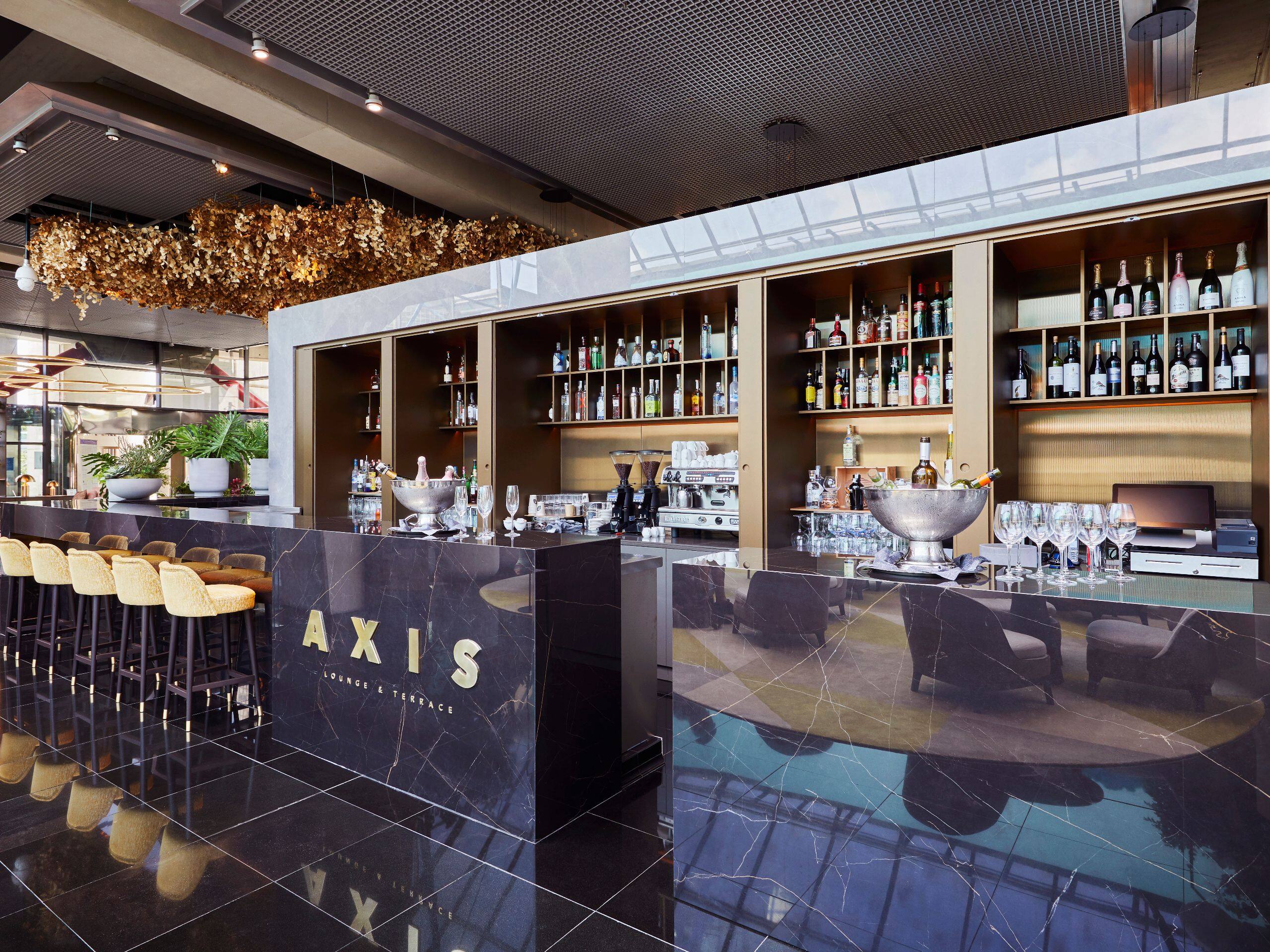 Modern Axis Lounge lobby bar with dark marble counter at Hyatt Regency Barcelona Tower